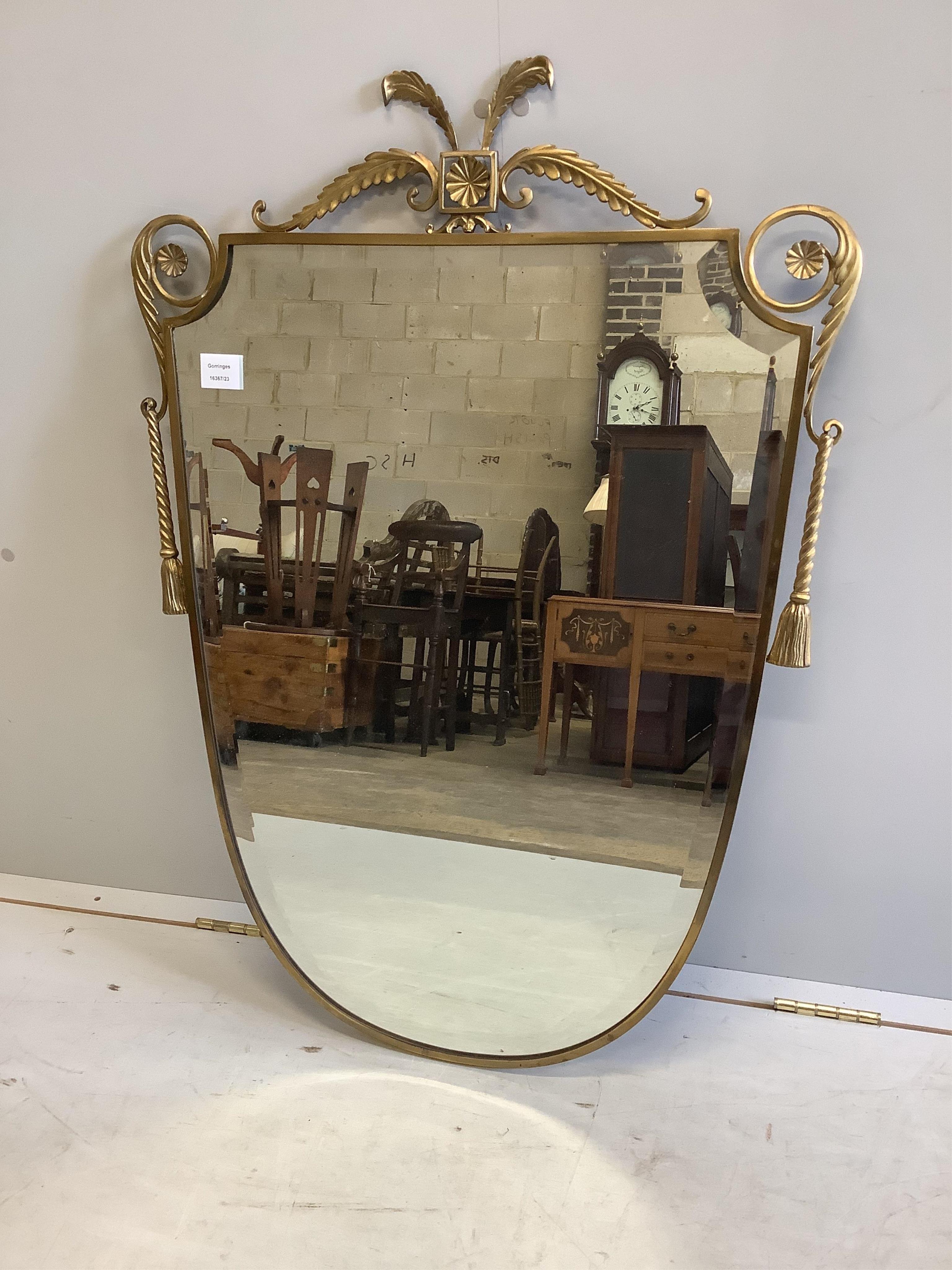 A mid century brass shield shaped wall mirror, width 66cm, height 94cm. Condition - good